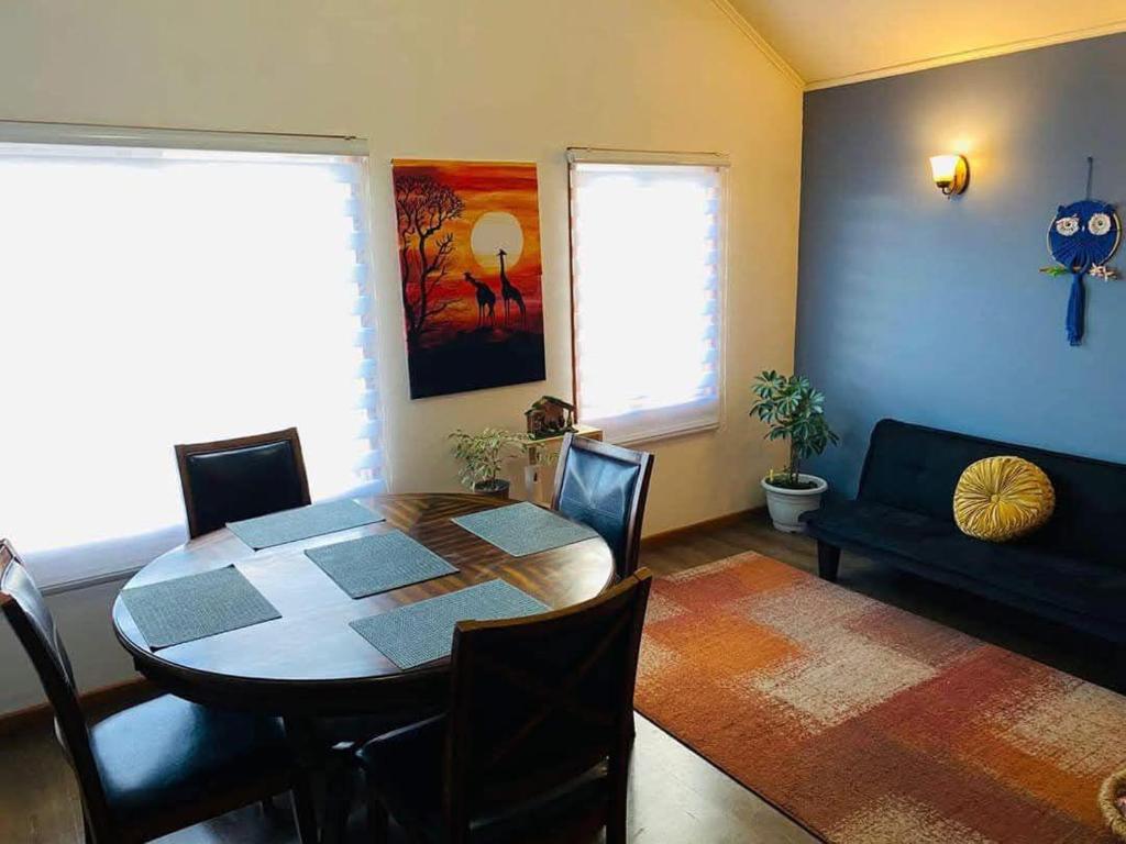 a dining room with a table and a couch at Casa Lepeley Colimilla in Frutillar