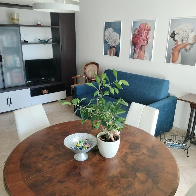 a living room with a wooden table with a plant on it at Nenni House in Sassari