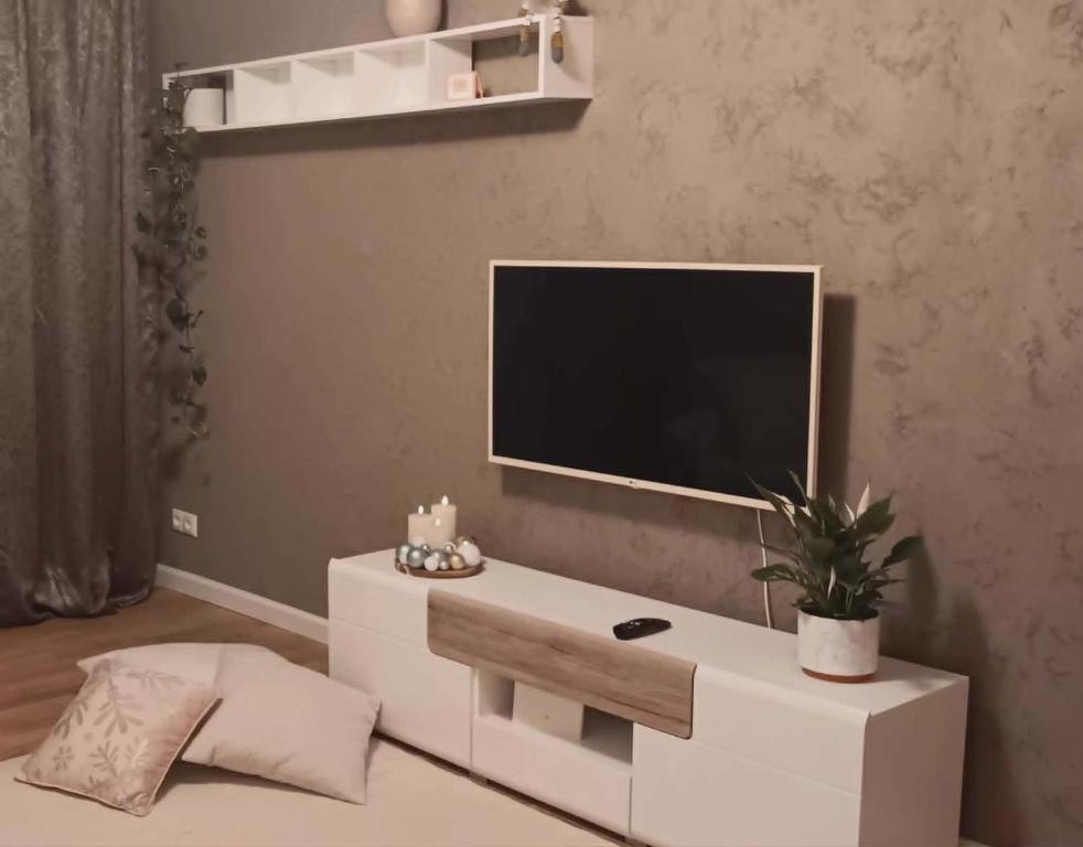 a white entertainment center with a tv on a wall at Savi sviit in Mooste