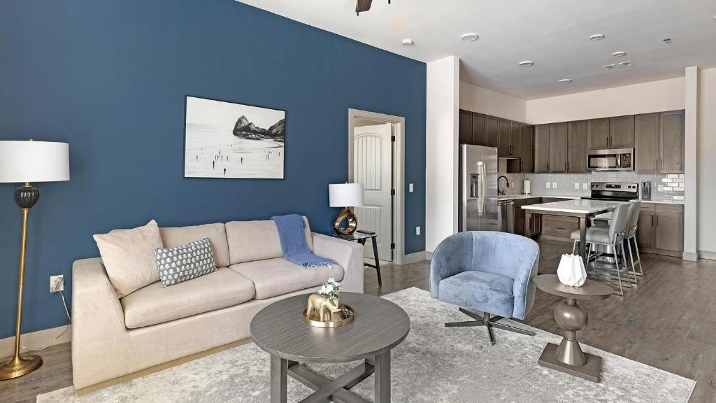 een woonkamer met een bank en een keuken bij Landing Stunning 2BD Courtyard Gym in Denton