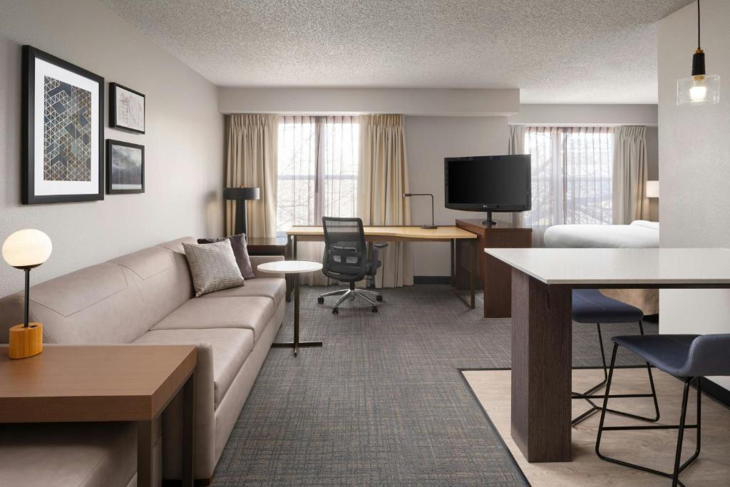 a living room with a couch and a table and a television at Residence Inn by Marriott Fort Collins in Fort Collins