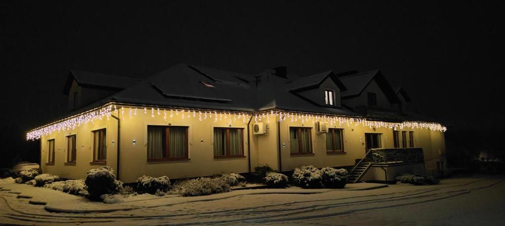 een huis met kerstverlichting 's nachts bij Lawendowy Dworek in Bałtów