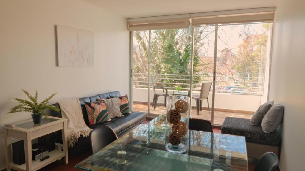un salon avec un canapé et une table en verre dans l'établissement Norus Providencia, à Santiago