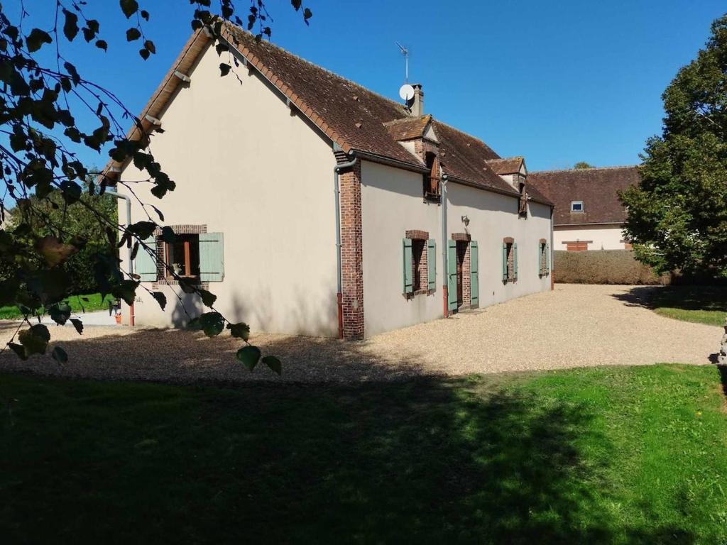 een oud wit gebouw met een dak bij Gîtes Le Gros Chêne in Meaucé