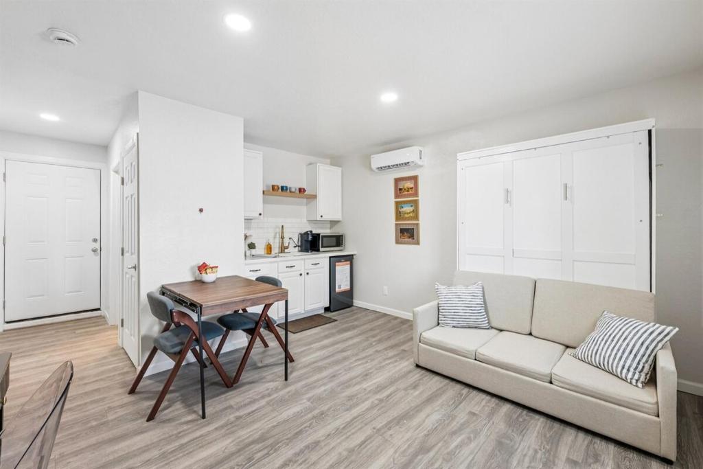 een woonkamer met een bank en een tafel bij Cozy Studio Retreat with Private Bath & Kitchenette in Tempe