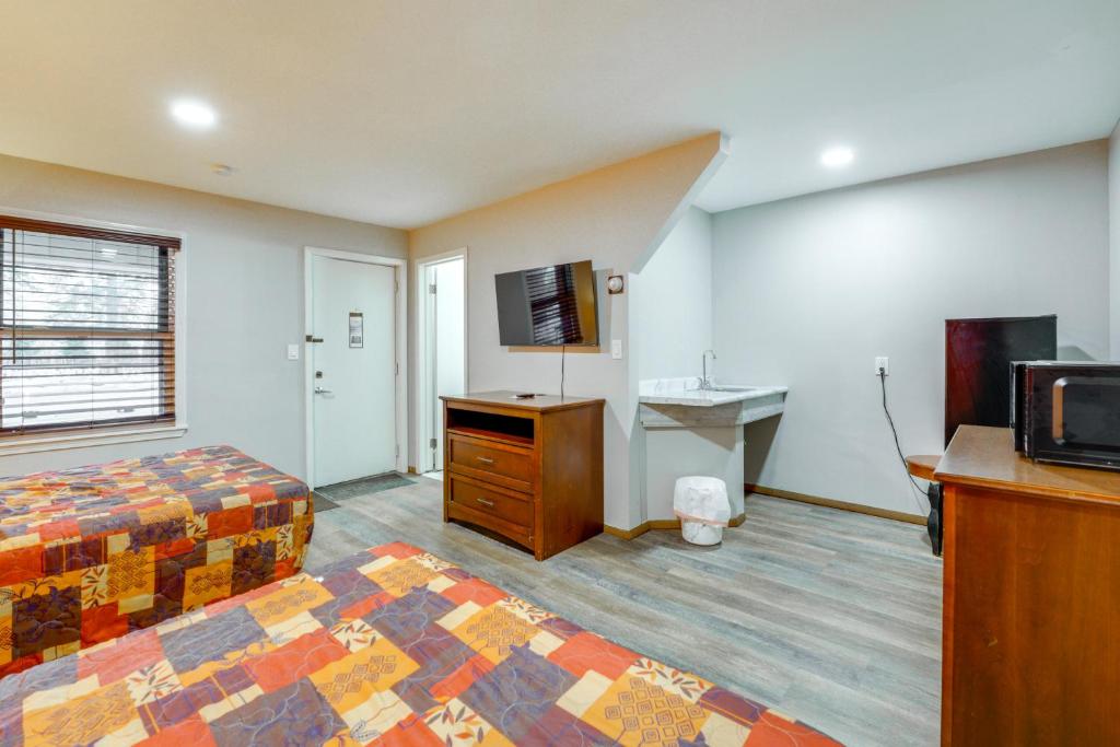 a bedroom with a bed and a desk and a television at Ski, Explore, Bring Pets! Studio 5 Mi to Pine Knob in City in the Village of Clarkson