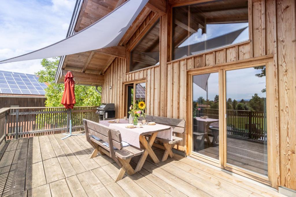 eine Terrasse mit Tisch und Stühlen auf einem Deck in der Unterkunft Biohof Beim Danner in Riedering