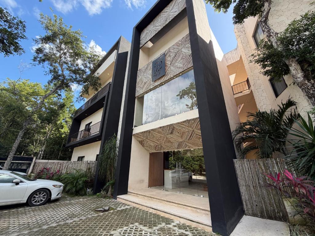 una casa con una grande finestra e un'auto parcheggiata davanti di Balam Tulum a Cedro