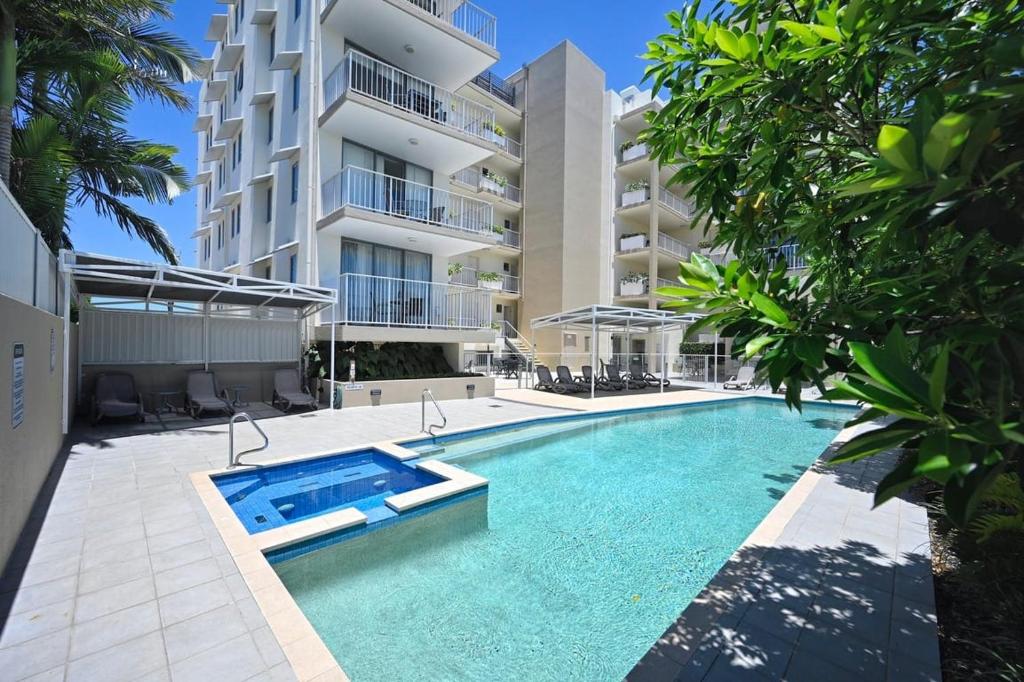 a swimming pool in front of a building at Ocean Views Retreat, Caloundra in Caloundra