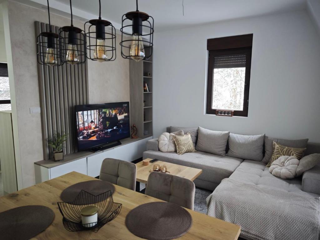 a living room with a couch and a table at Vidak apartman in Divčibare
