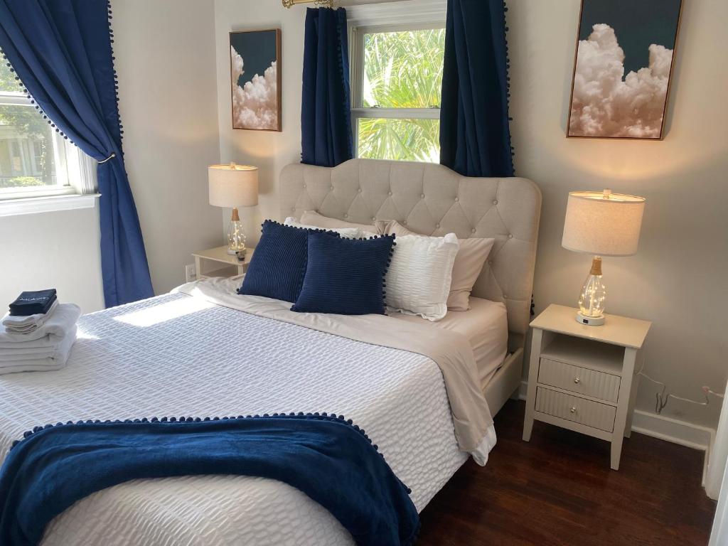 a bedroom with a large bed with blue curtains at The Hourglass Inn- Unit B in Savannah