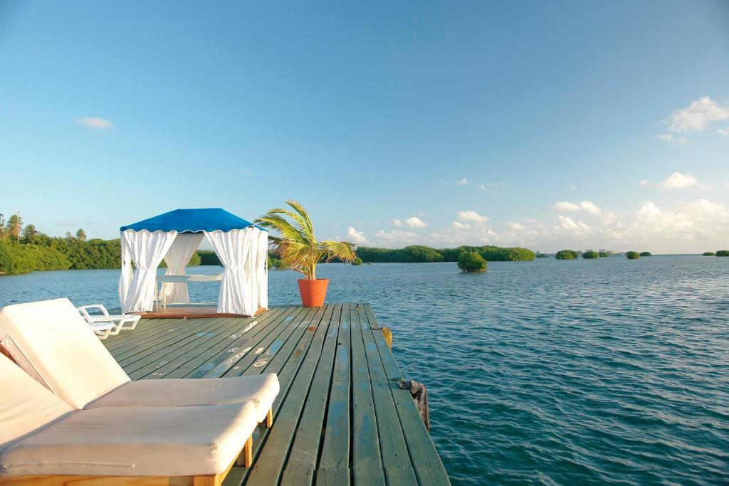 a dock with a gazebo and chairs on the water at Decameron Marazul - All Inclusive in San Andrés