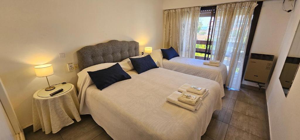 una camera da letto con due letti e una finestra di Hotel Soleares a Mar del Plata