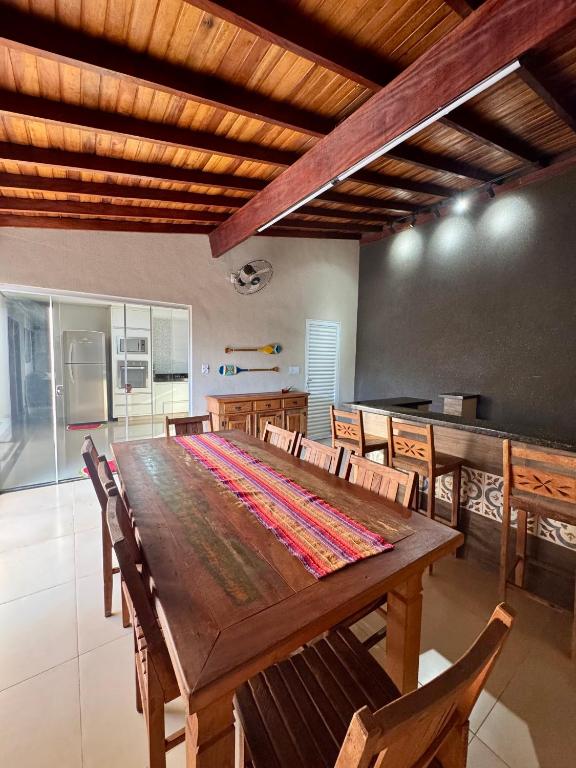 a dining room with a large wooden table and chairs at Casa Completa Para Dias Perfeitos in Olímpia