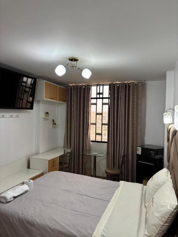 a bedroom with a bed and a desk and a table at Hospedaje Ariana in Supe