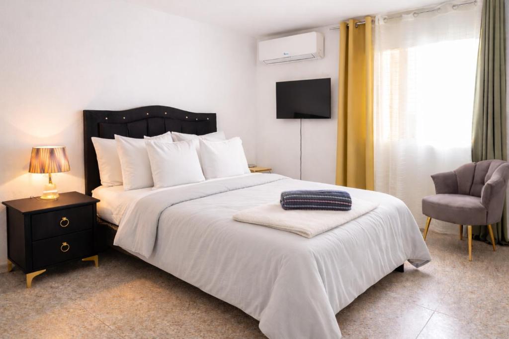 a bedroom with a bed and a chair and a television at One bedroom,central location Wifi&Ac in Cancino