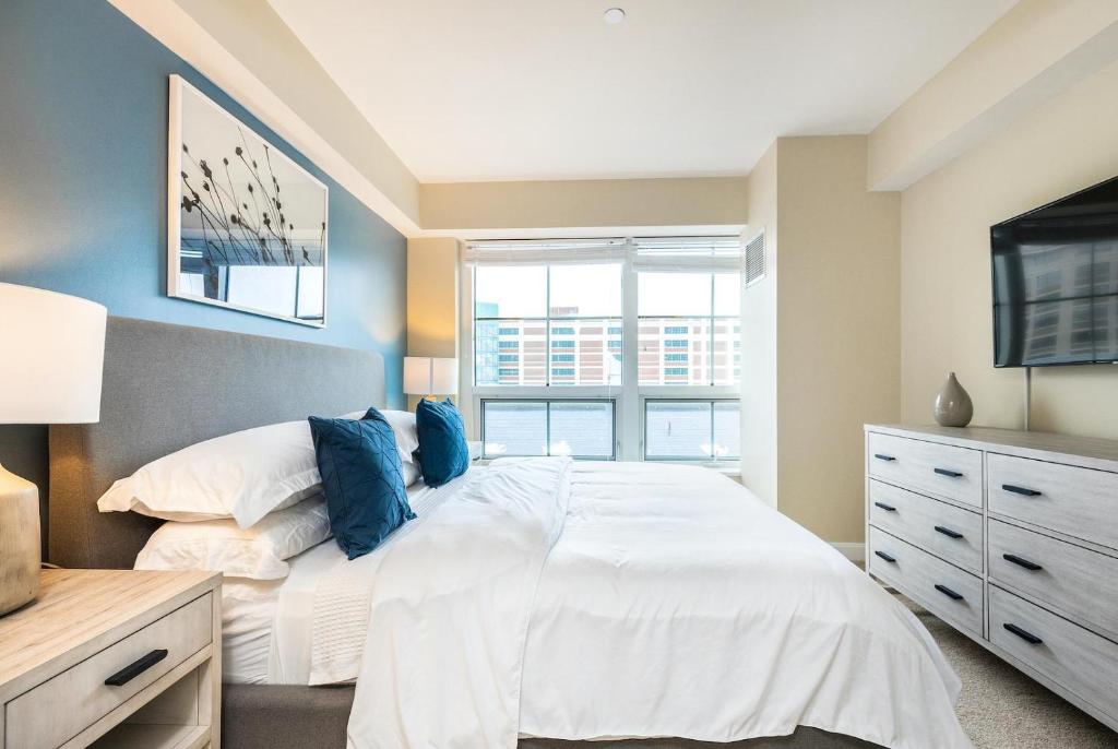 una camera da letto con un letto bianco e una finestra di Landing Chic 2BD Gym Pool a Frederick