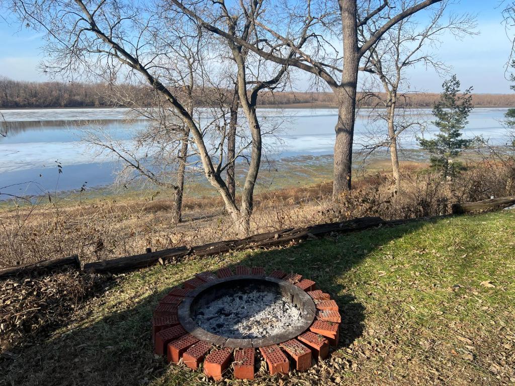 a fire pit in the grass next to a body of water at Sunset Cottage in Havana