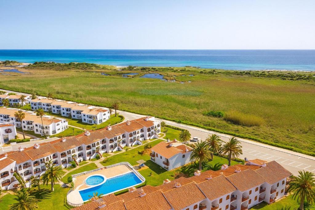 an aerial view of a resort with a swimming pool and the ocean at Turquoise Menorca By the Sea in Son Bou