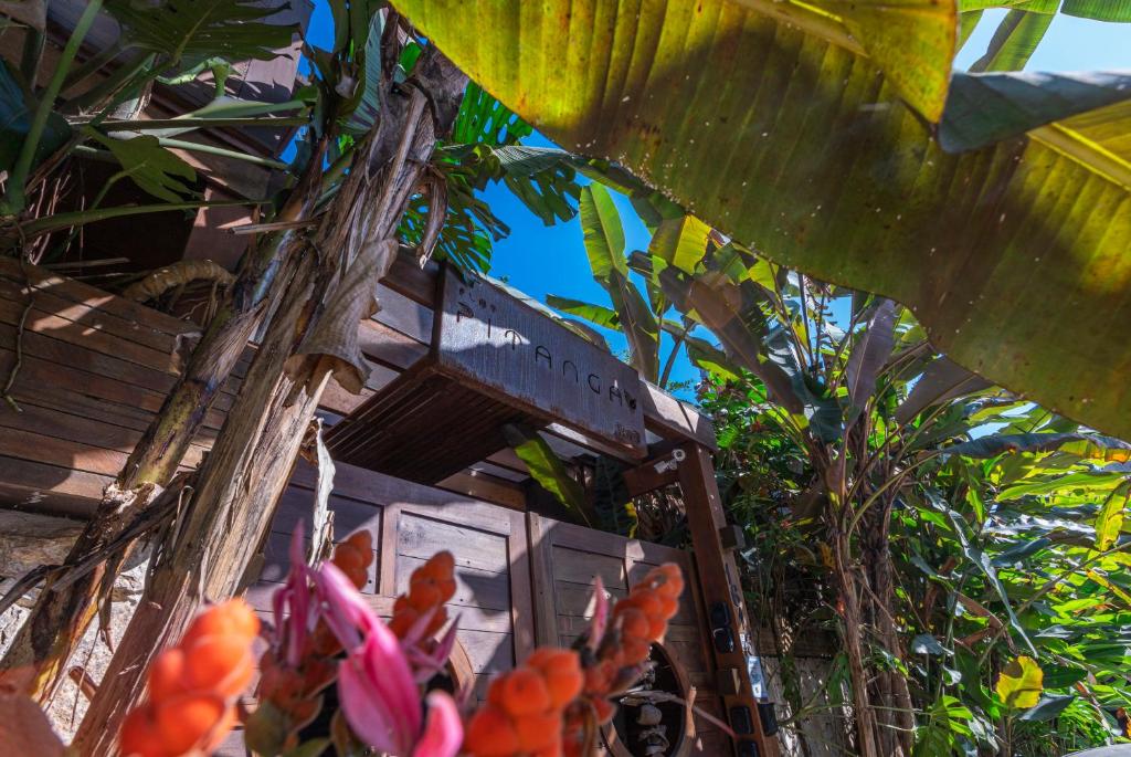 een gebouw met veel bloemen en bomen bij Flat Pitanga in Camburi