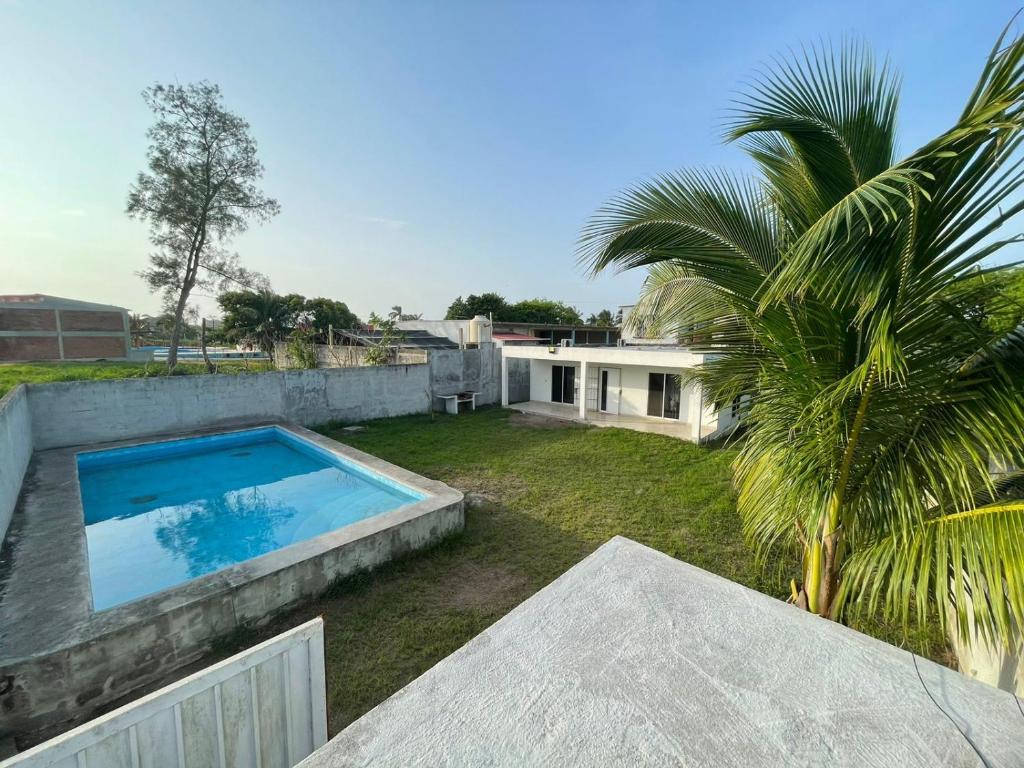 un cortile con piscina e una casa di Casa de Playa Elsa a La Vigueta