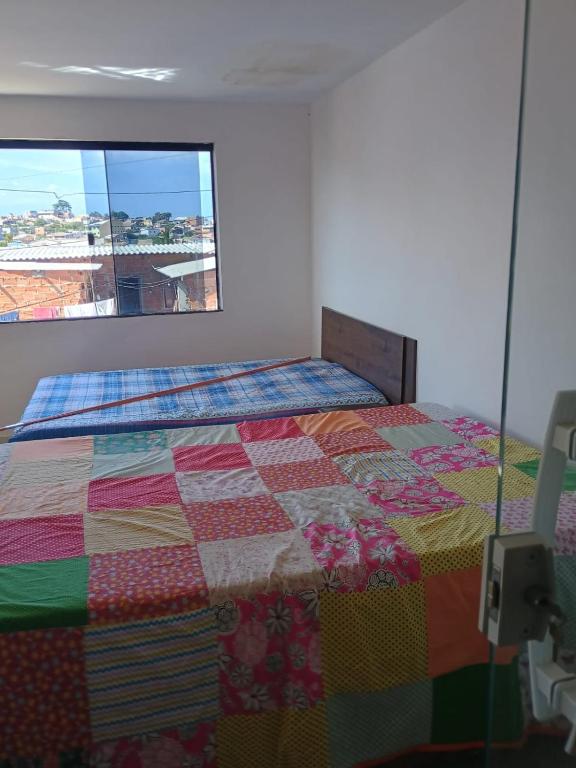 a bedroom with a bed with a colorful quilt at Regina in Cabo Frio