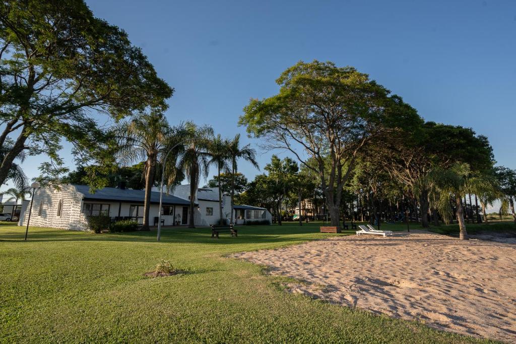 un parco con panchina e alberi e un edificio di La Estancia a Federación