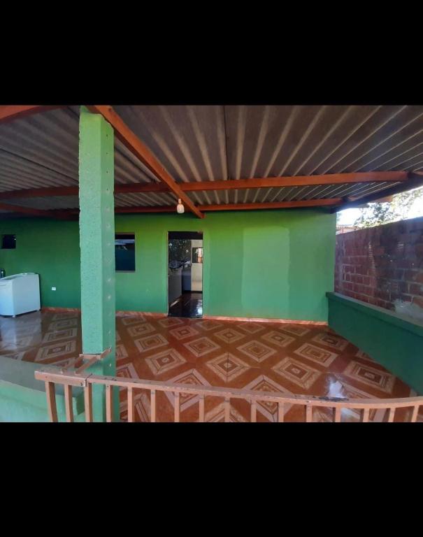 a room with green walls and a wooden floor at Casa indisponíve in Maracaju
