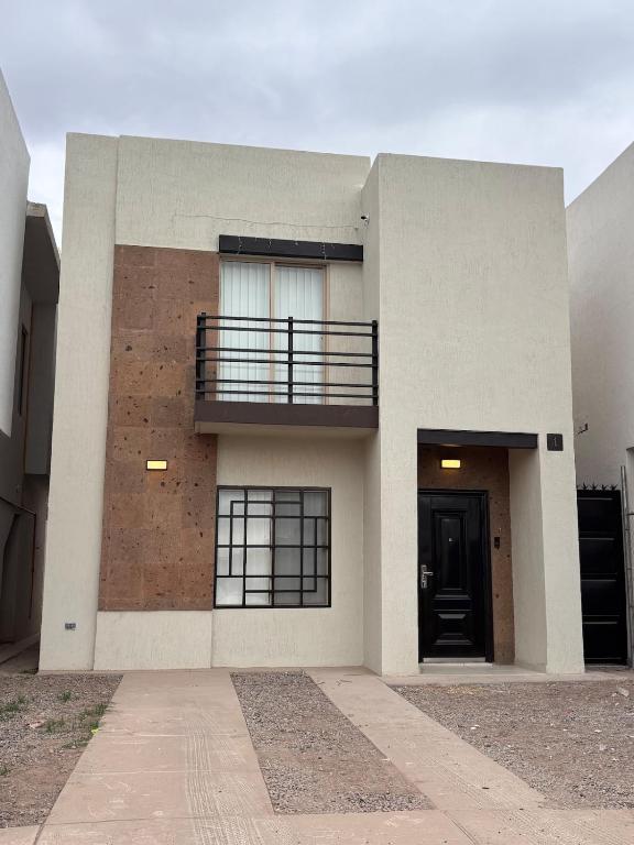 a large white building with a balcony and a door at Residencia Flores in Hermosillo