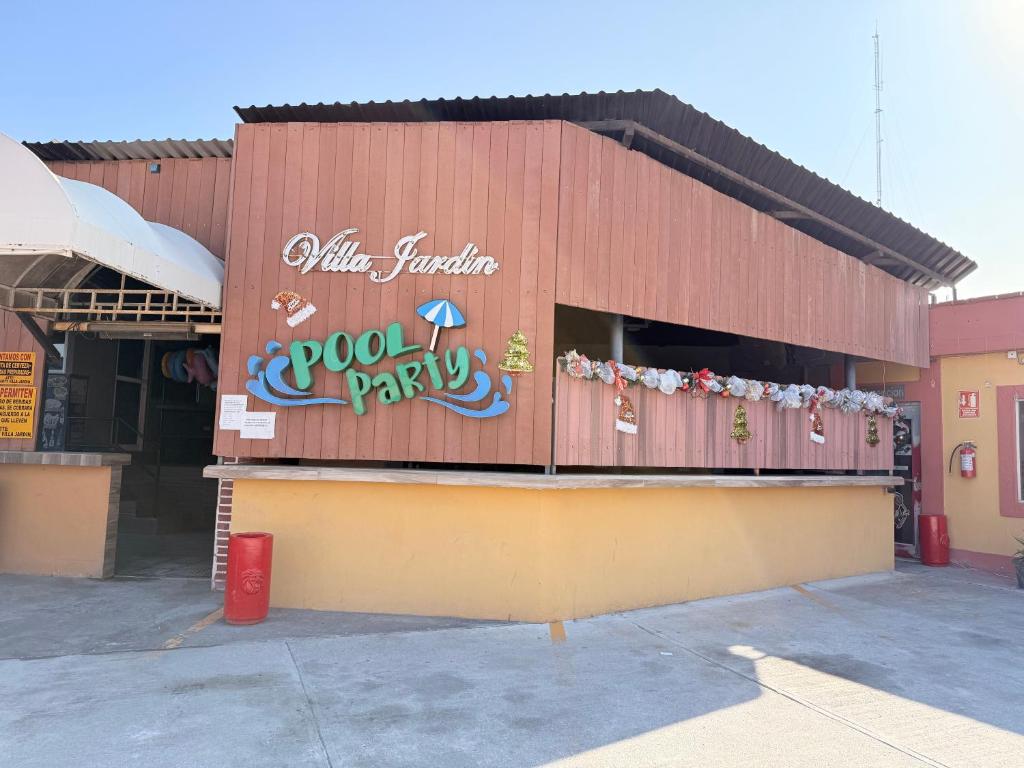 un ristorante con un cartello sul lato di un edificio di Hotel Villa Jardin a Matamoros