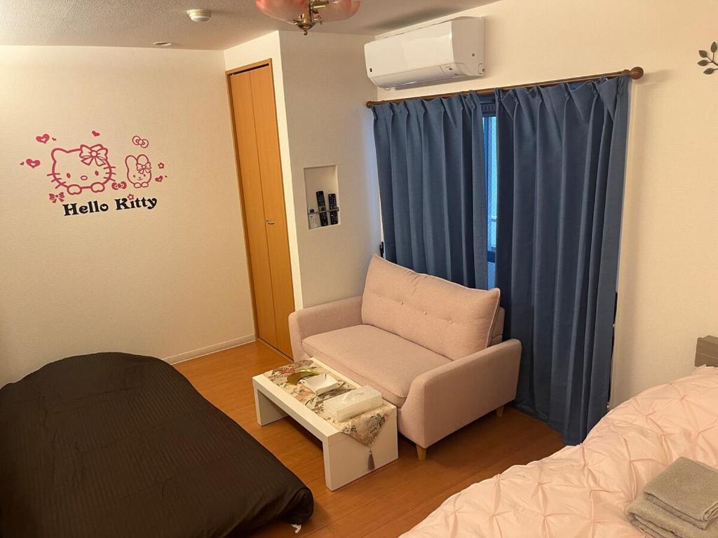 a room with a bed and a chair and a table at 202basichostel in Osaka