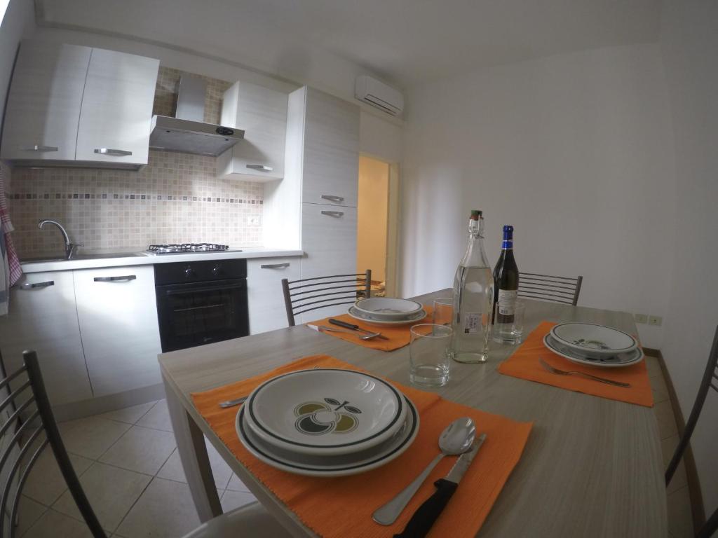 a kitchen with a table with plates and wine bottles at Procaccini Apartment in Bologna