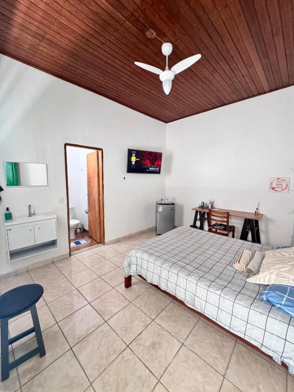 een slaapkamer met een bed en een plafondventilator bij Suíte 2 Completa - Wi-Fi e Netflix in Jundiaí