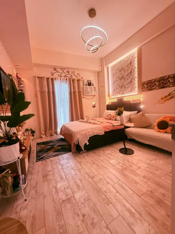 a bedroom with a bed and a couch at The Fyangz Luxe Staycation Near Anjo World in Cebu
