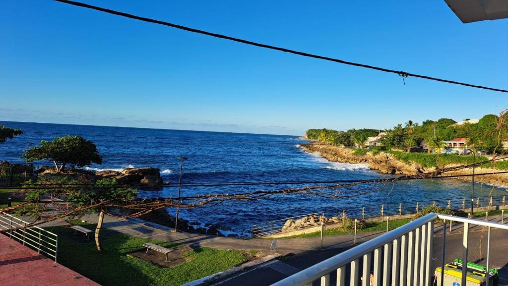 uitzicht op de oceaan vanaf een balkon bij La résidence du sportif Bernard in Anse-Bertrand