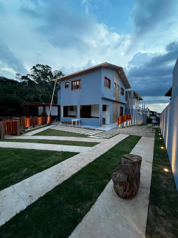 a large white house with a lawn in front of it at Pousada do Rui in Caparaó Velho