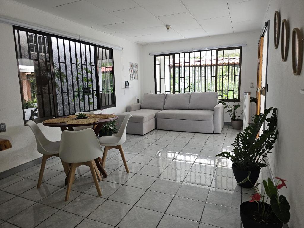 een woonkamer met een bank, een tafel en stoelen bij Casa Burbujas in Puerto Jiménez