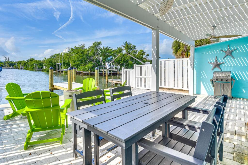 a wooden table and chairs on a deck with the water at Near Beaches Waterfront Gem in Anna Maria Island! in Anna Maria Island