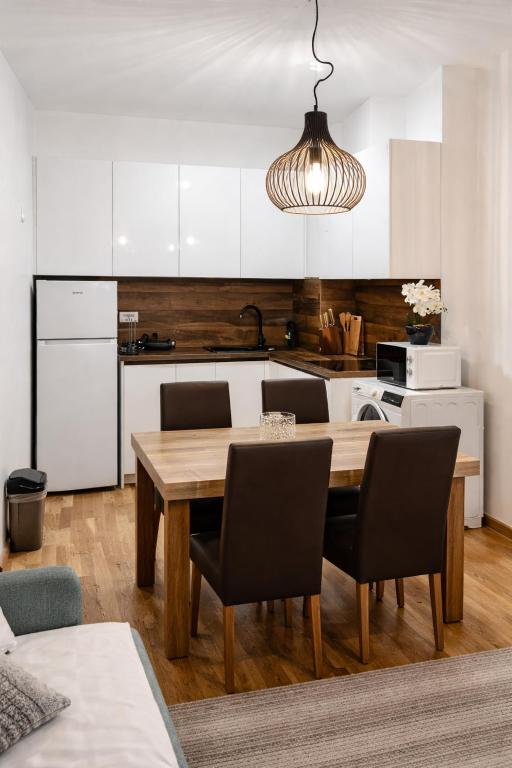 a kitchen with a wooden table with chairs and a dining room at Mountain View -ski & mountain retreat, Apartment 01 PRIZEMLJE u Premium objektu in Jahorina