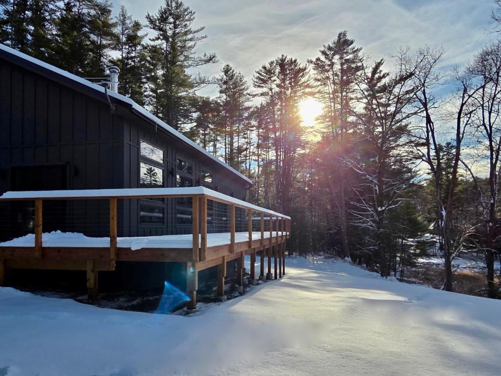 una casa nella neve con il sole sullo sfondo di White Pine Chalet a Yulan