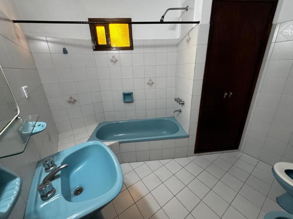 La salle de bains est pourvue d'un lavabo bleu et d'une baignoire. dans l'établissement Duplex amplio y tranquilo 3habs 2baños, à San Bernardo