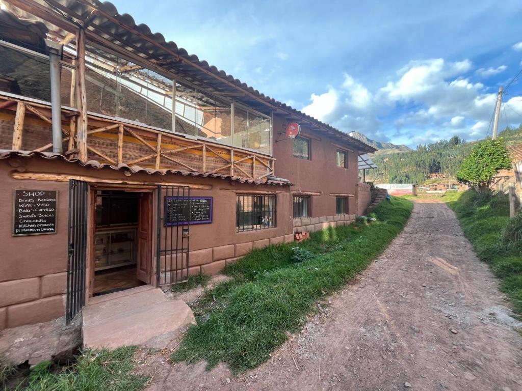 een gebouw aan een onverharde weg naast een straat bij Intihuatana Hostel in Pisac
