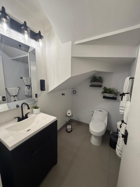 een witte badkamer met een wastafel en een toilet bij New House Near The Beach in Ensenada