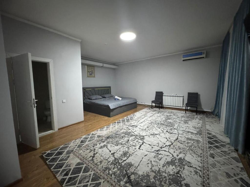 奇姆肯特Grand RR的一间带床和地毯的卧室