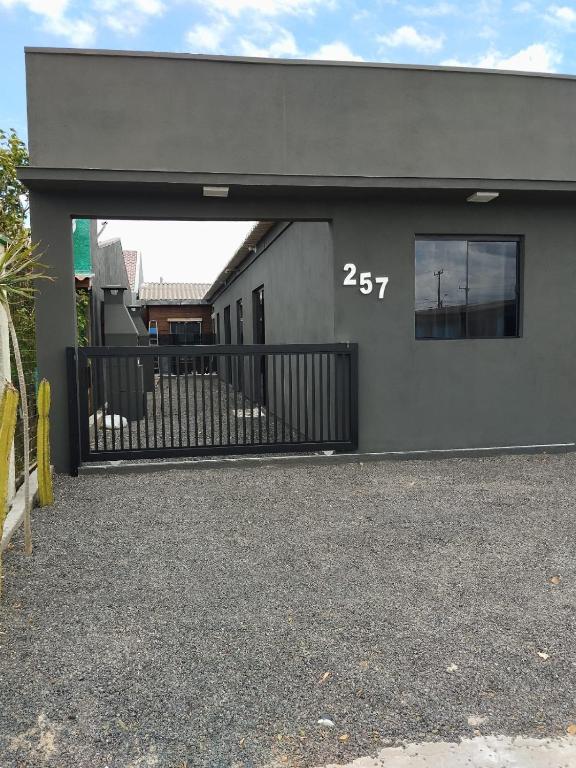 een grijs gebouw met een deur met het nummer bij Casa temporada estrela do mar in Imbé