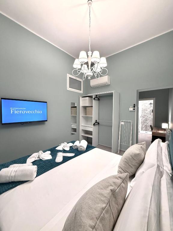 a bedroom with a large bed with a tv on the wall at Foresteria del Genio - Luxury Suites & Urban Spa in Palermo