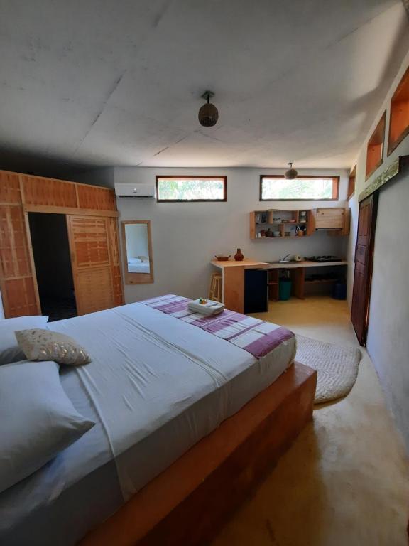 een slaapkamer met een groot bed en twee ramen bij Casa kuxtal in Zipolite