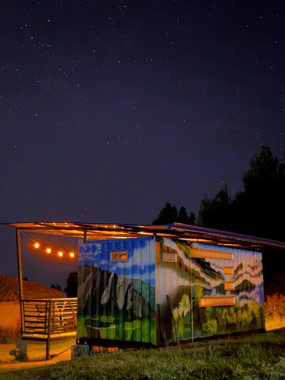 a building with a painting on it at night at Sendero Nativo Glamping in Monguí