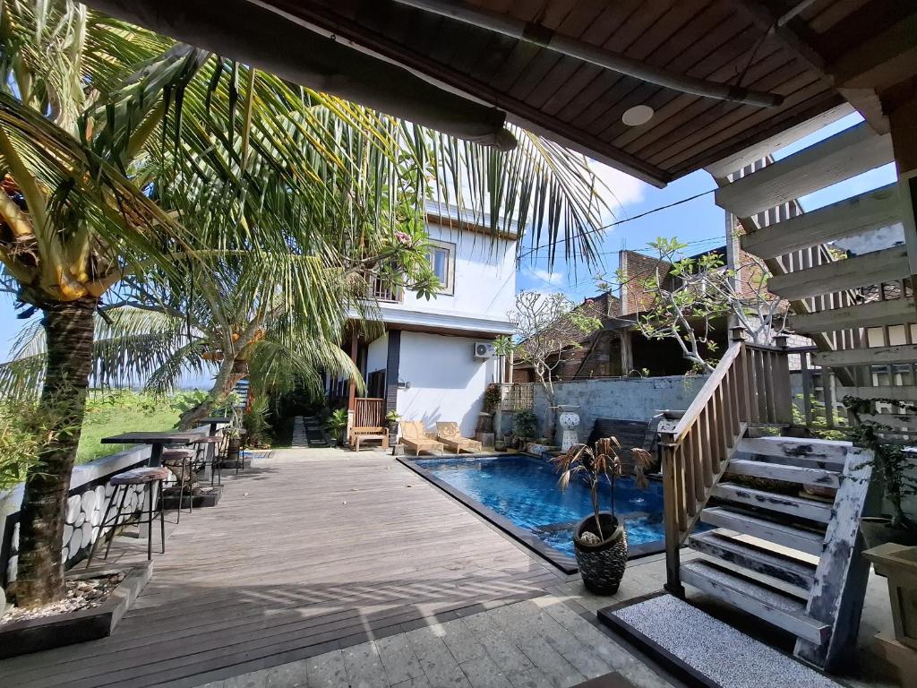 a house with a swimming pool and a wooden deck at suffers villa medewi in Medewi