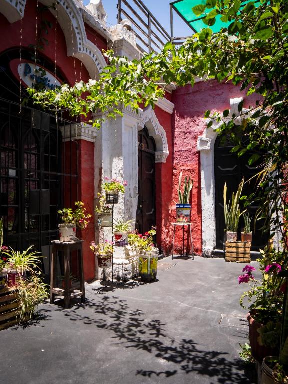 an entrance to a red building with potted plants at Casona Cruz Verde in Arequipa